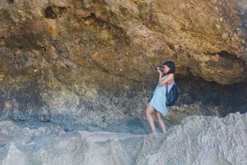A person taking a photo in a rocky cave. 1