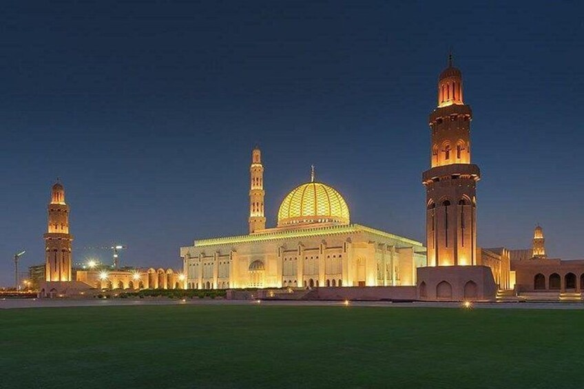 A mosque with a large dome and two minarets, surrounded by a green field. 2