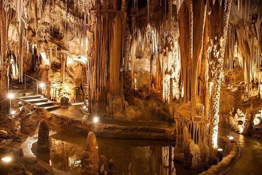 Una grotta con stalattiti, una vasca d'acqua e una scala. 2