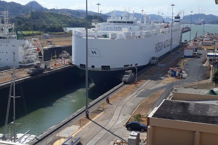 Un grand navire blanc était amarré dans un port, avec un paysage montagneux en toile de fond. 1