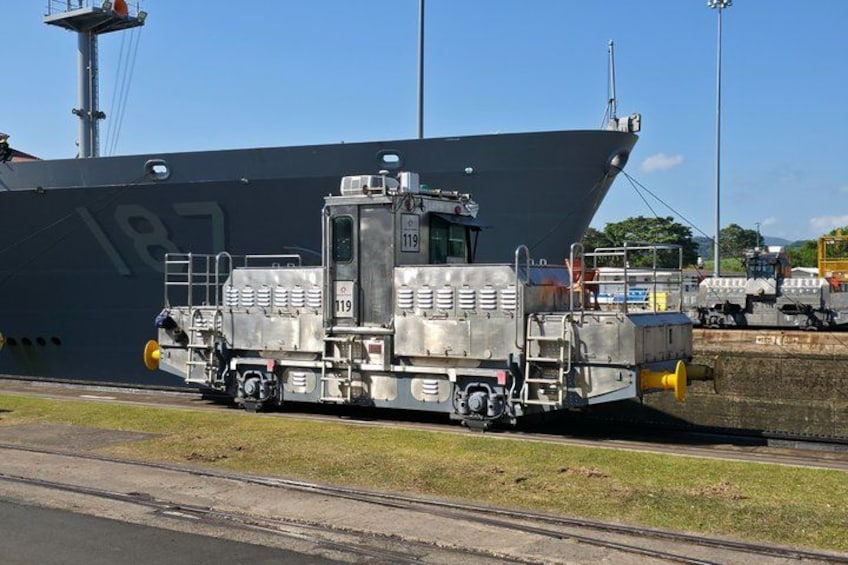 Een groot schip in de haven, met een sleepboot ervoor. 3