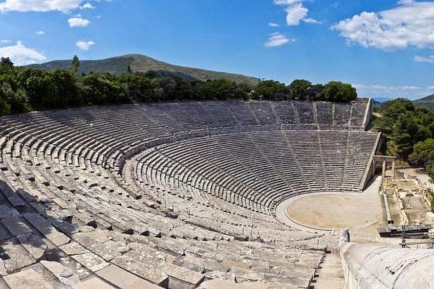 Un anfiteatro antiguo con asientos escalonados y un escenario central. 1