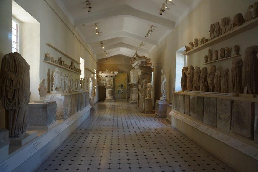 Un pasillo de museo con esculturas y relieves clásicos exhibidos. 5