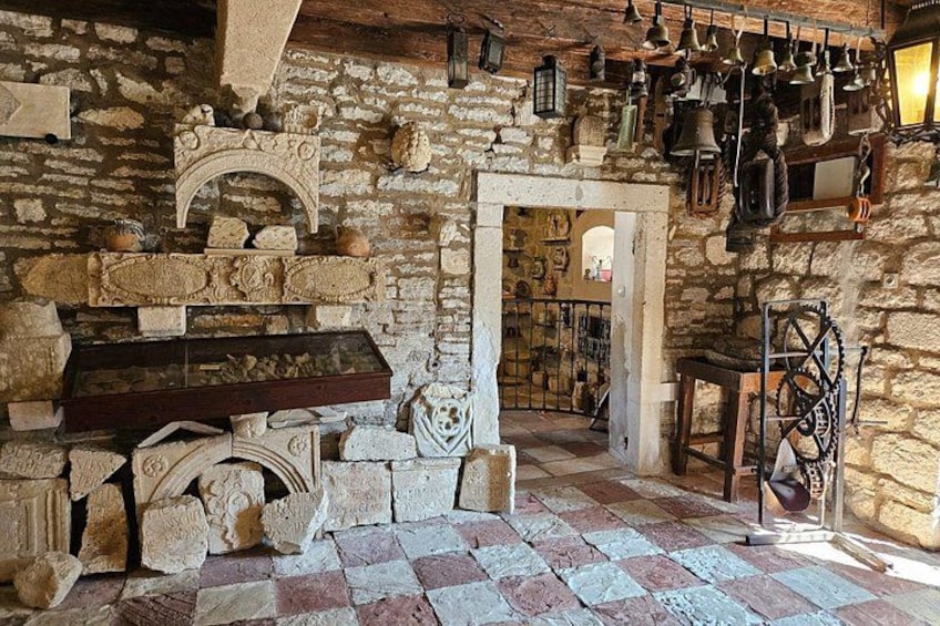 Un interno rustico con pareti in pietra, una panca di legno e diversi oggetti d'antiquariato. 4