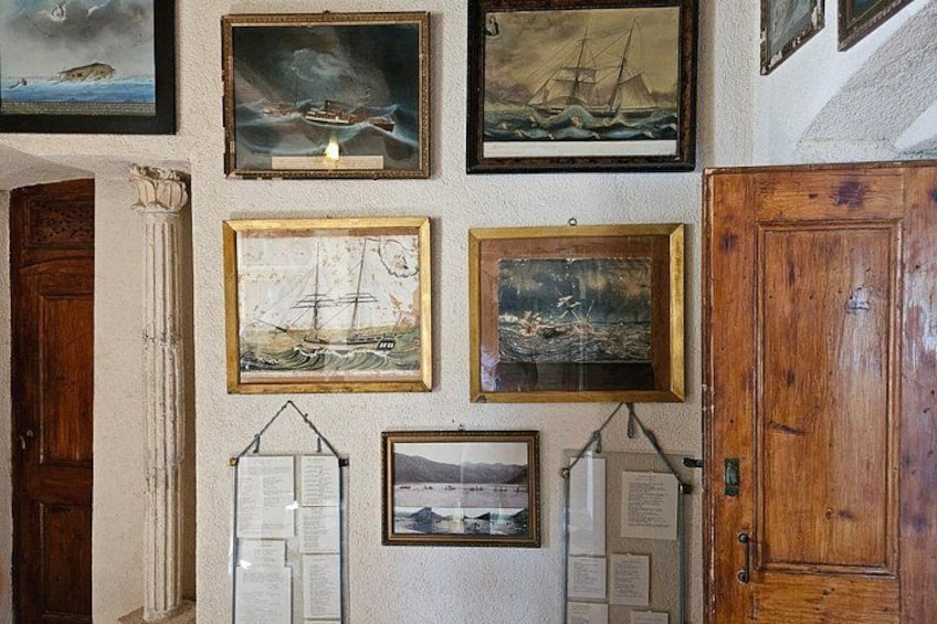 Un muro con quadri a tema marittimo e una porta di legno. 5