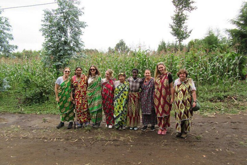 A group of people standing in a rural area with crops in the background. 2