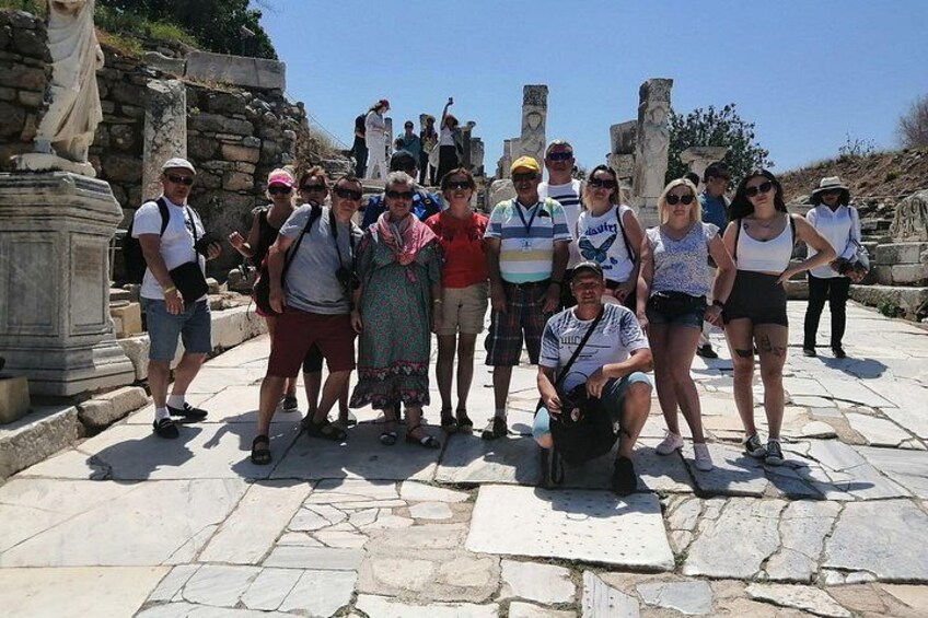 A group of people posing in front of ancient ruins with stone structures and columns. 4