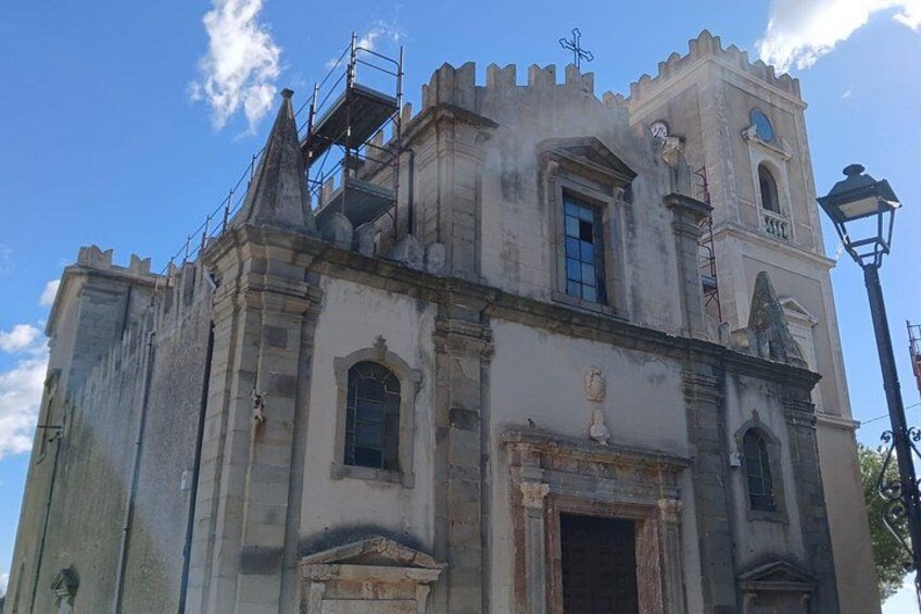 A historic building with a bell tower, scaffolding, and a street lamp. 2