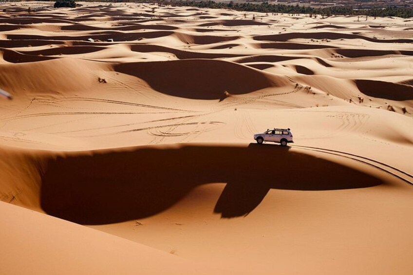 Un veicolo che si muove attraverso un paesaggio di dune sabbiose. 5