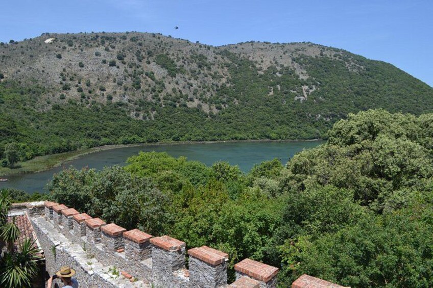A stone wall, a lake, and a forested hill. 2