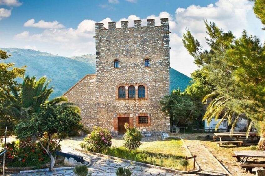 A stone tower with a wooden door, surrounded by greenery and a stone pathway. 4