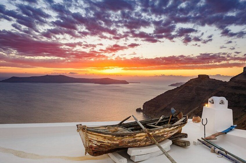 A wooden boat on a white surface, a white structure, and a sunset over the sea. 3