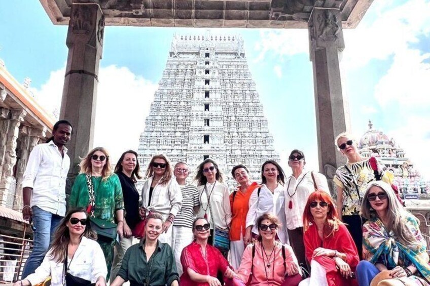 A group of people posing in front of a large temple structure. 1