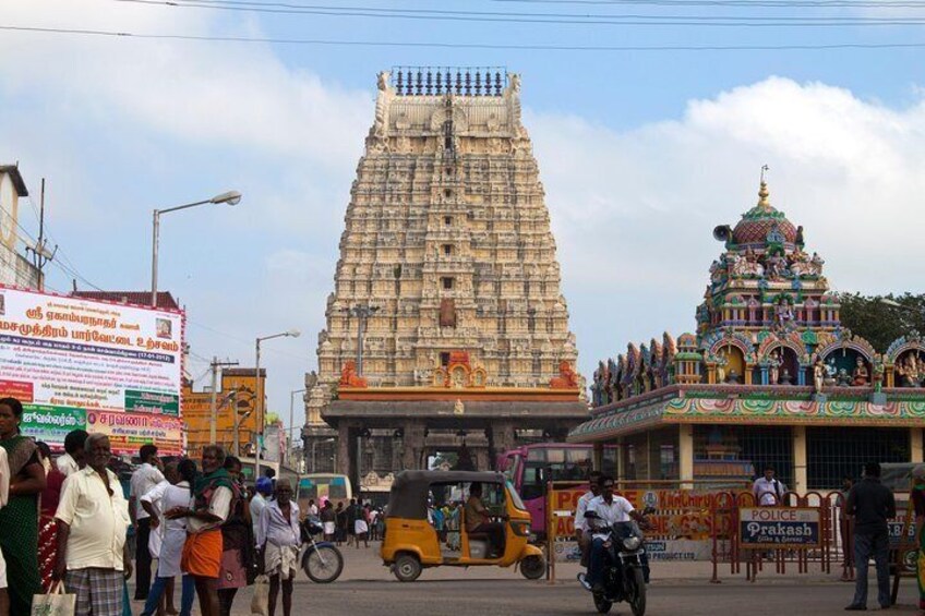 A temple with a large gopuram, a busy street with auto-rickshaws, and a colorful shrine. 1