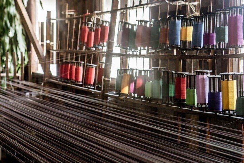 A textile loom with colorful spools of thread. 2