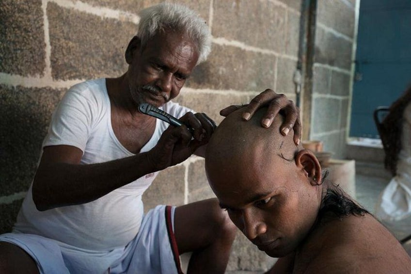 A person holding a comb over another person's head. 5