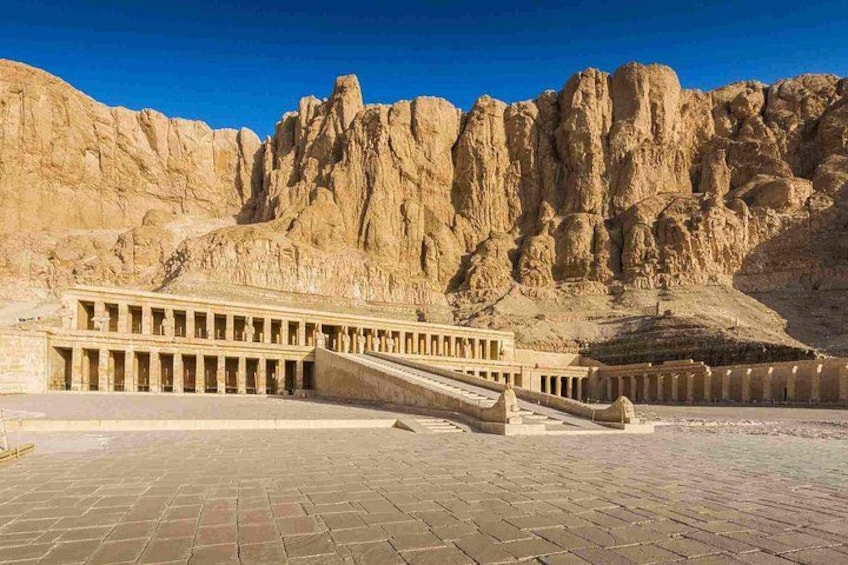 A pyramid complex with a large pyramid and a smaller one in the background, surrounded by rocky terrain. 3