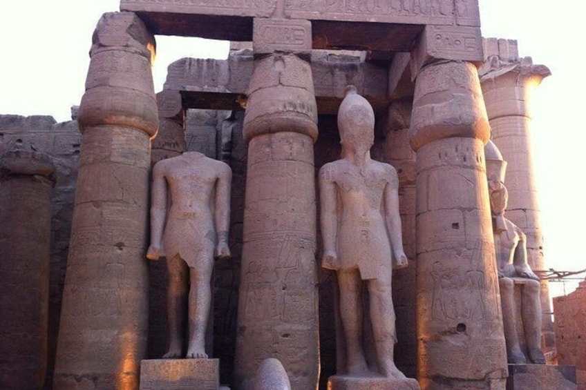 Anciennes colonnes égyptiennes en pierre, avec des statues placées entre elles. 1