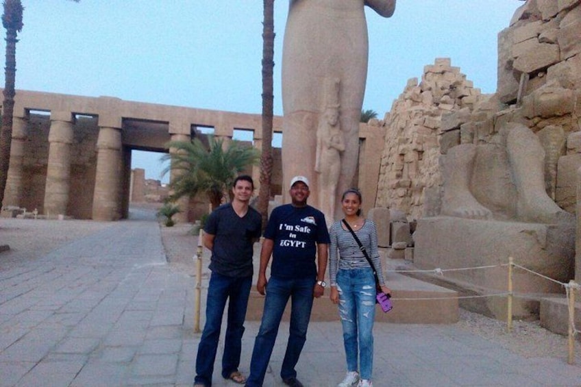 Een groep mensen staat voor een oud-Egyptische standbeeld. 3