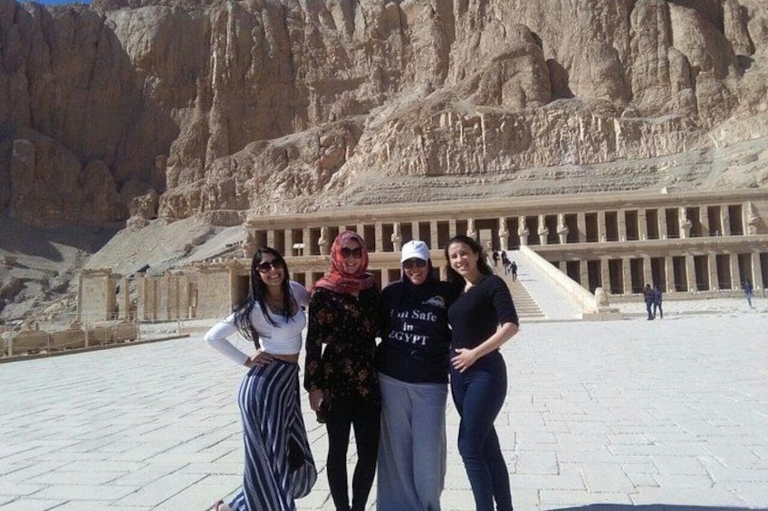 A group of people standing in front of an ancient Egyptian temple with hieroglyphics on the walls. 2