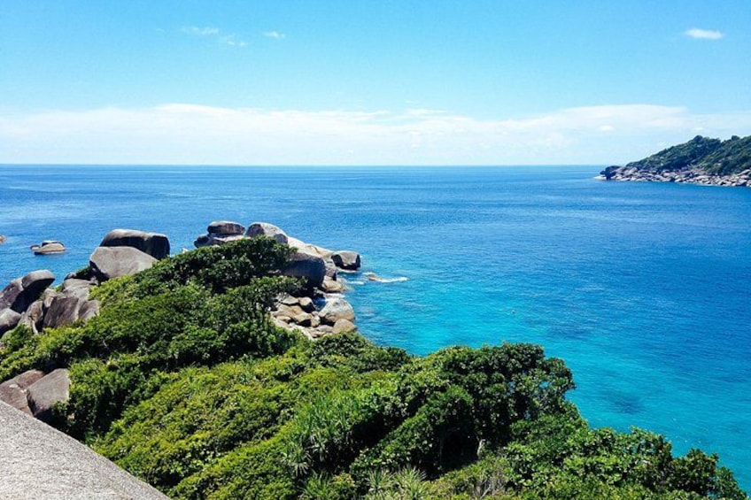 Paesaggio costiero con affioramenti rocciosi, vegetazione verde intensa e mare cristallino. 4