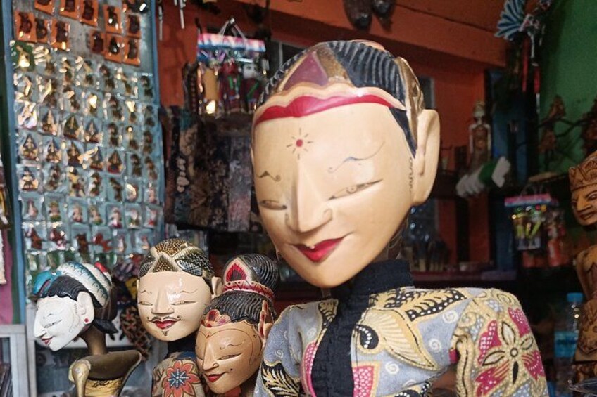 A collection of traditional masks and a large ornate mask in a shop. 3