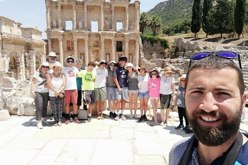 Eine Gruppe von Menschen steht vor alten Ruinen mit Säulen und Steinbauten. 5