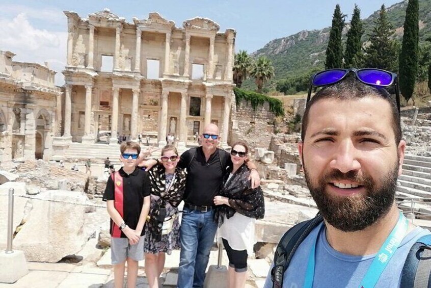 A group of people standing in front of ancient ruins with columns and steps. 1