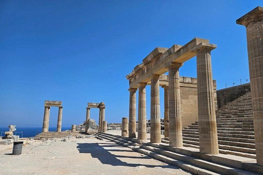 Ancient ruins with columns and steps, overlooking the sea. 5