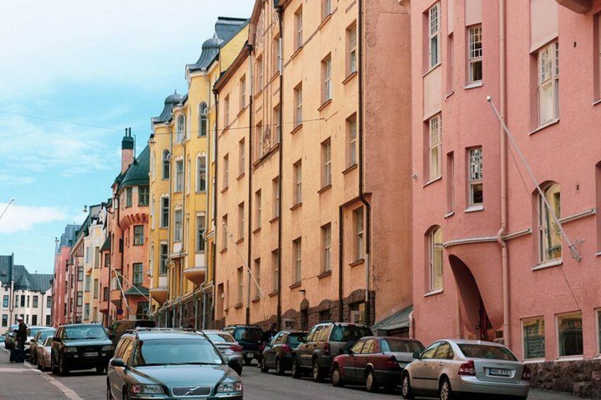 A street lined with colorful buildings and parked cars. 3