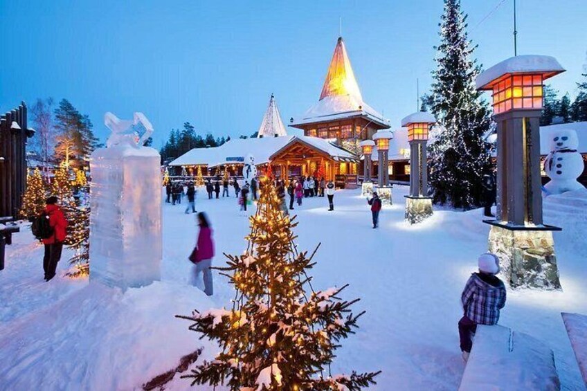 A snowy outdoor area with a building, ice sculptures, and Christmas trees. 5