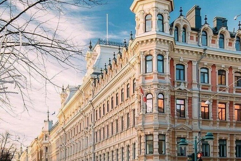 Un bâtiment historique à l’architecture riche et travaillée, doté de grandes fenêtres et arborant un drapeau. 4