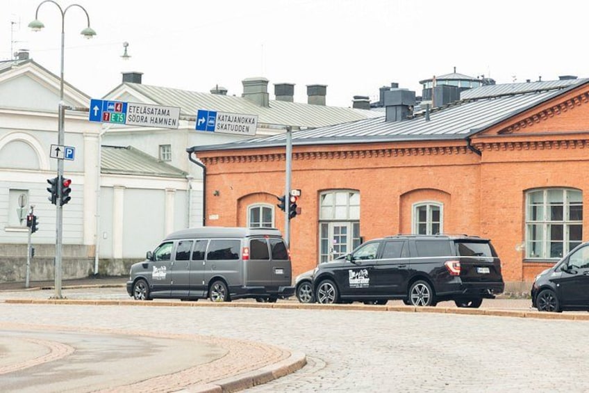 Una calle con coches aparcados, un edificio de ladrillo y señales de dirección. 4
