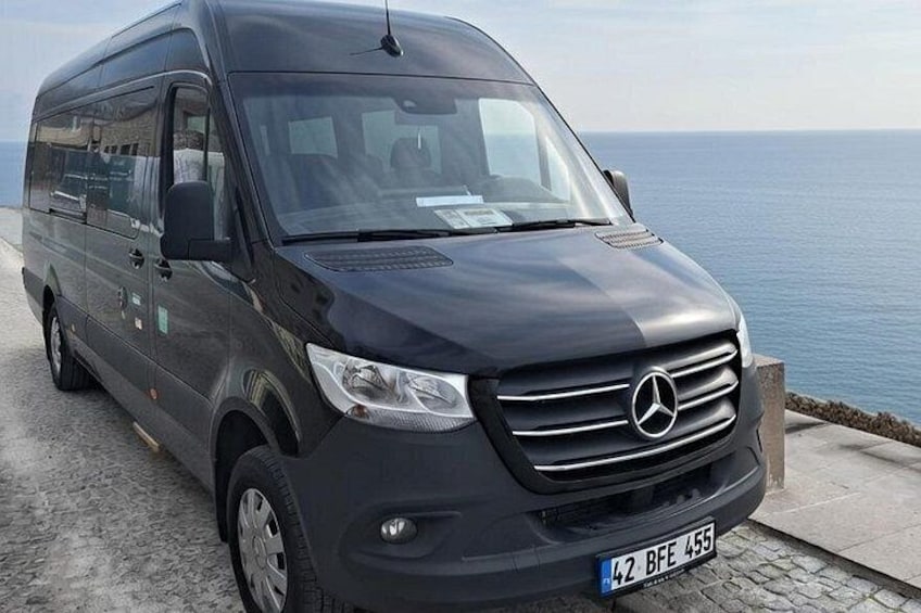 A black Mercedes van parked by the seaside. 2