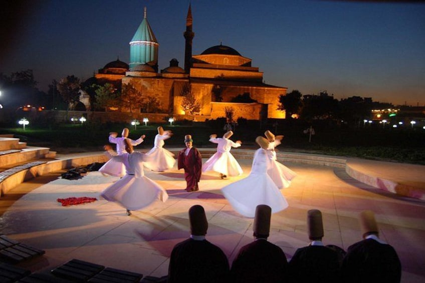 A group performing a dance in front of a historic building at dusk. 5