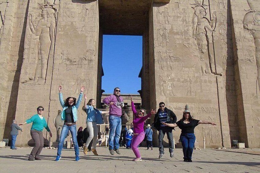 A group of people posing in front of ancient Egyptian hieroglyphs. 3