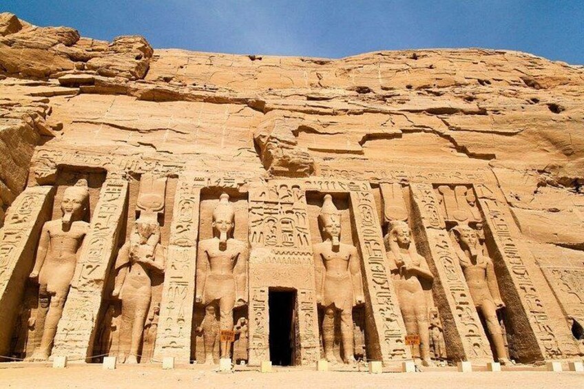 A large rock face with ancient Egyptian statues and hieroglyphics. 5