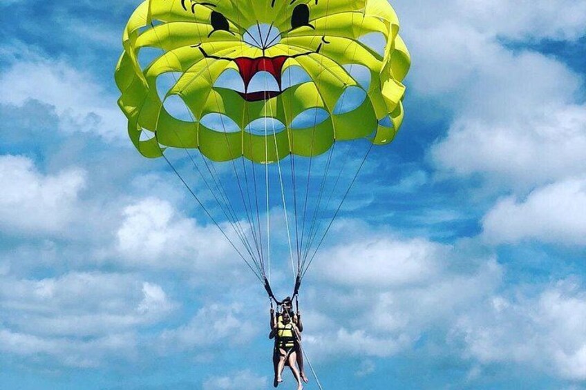 Una persona che si lancia in paracaduta con un paracadute giallo sullo sfondo di un cielo azzurro. 2