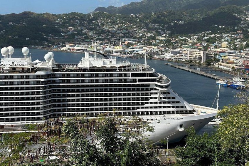 Un gran crucero amarrado en un puerto con un paisaje urbano al fondo. 3