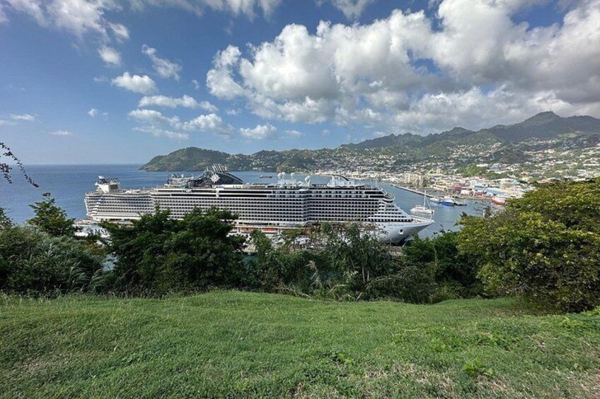 Un crucero amarrado en un puerto con montañas al fondo y cielo despejado. 5