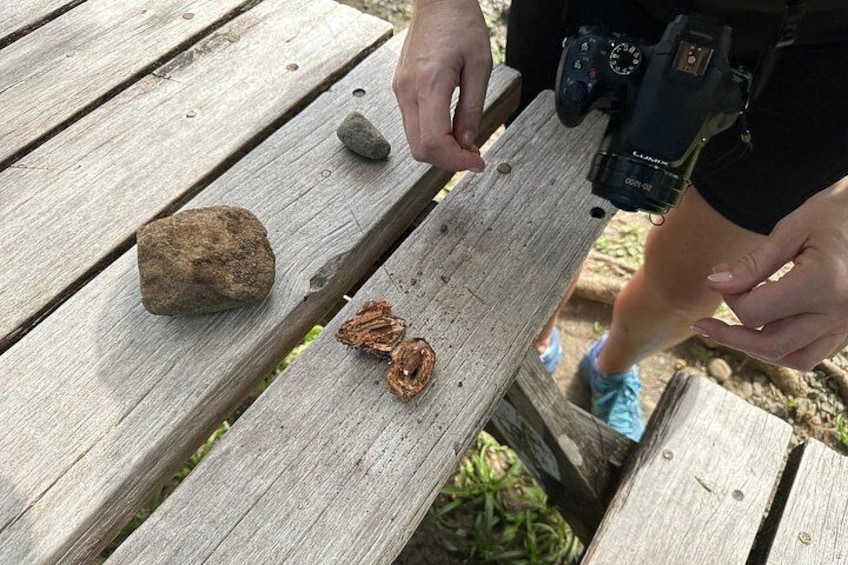 A wooden picnic table with a rock and a piece of copper wire. 5