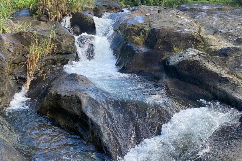 A small waterfall cascading over rocks in a natural setting. 4