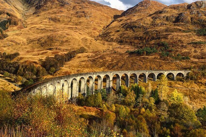 A stone viaduct over a river in a hilly landscape. 2