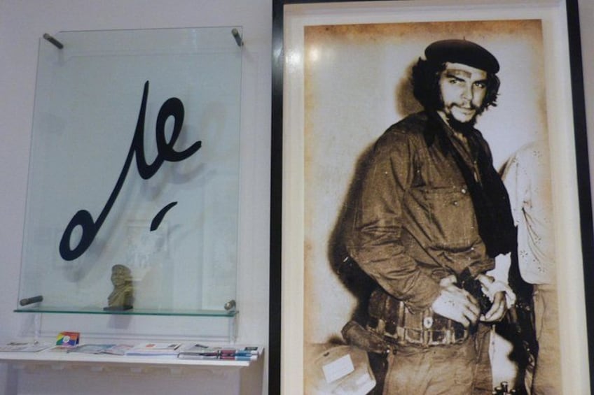 A glass display case with a handwritten sign and a framed photograph of a person. 1