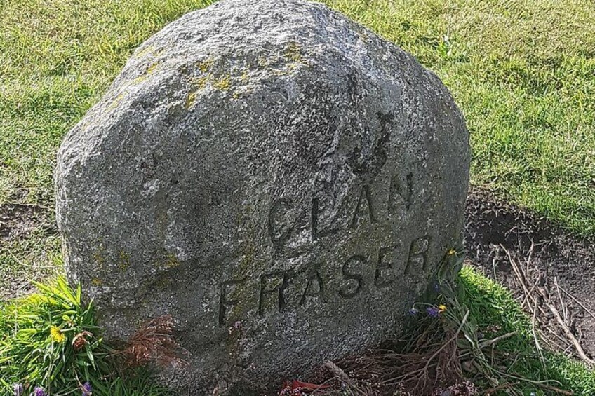 A large, weathered stone with the inscription 'CLAN PHASER' on it. 5