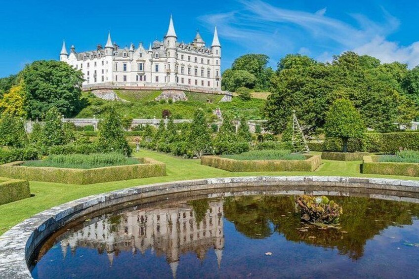A castle on a hill with a reflective pond in the foreground. 1