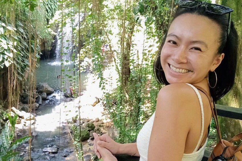 A person standing by a stream in a forested area. 5