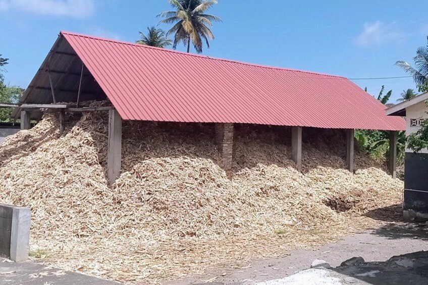 Ein Gebäude mit rotem Dach, umgeben von großen Holzchips-Haufen. 2