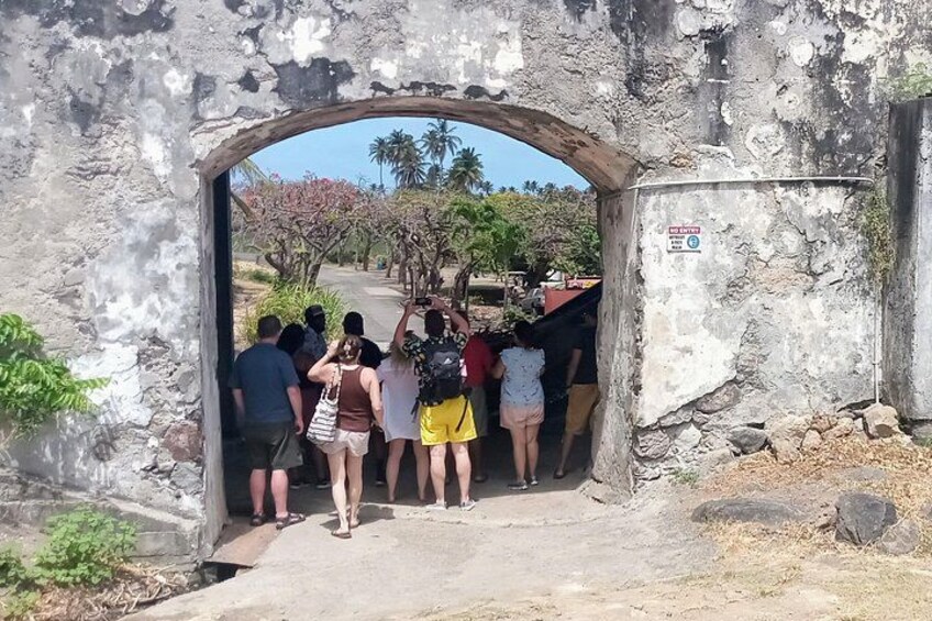 Eine Gruppe von Menschen betritt ein steinernes Tor. 4