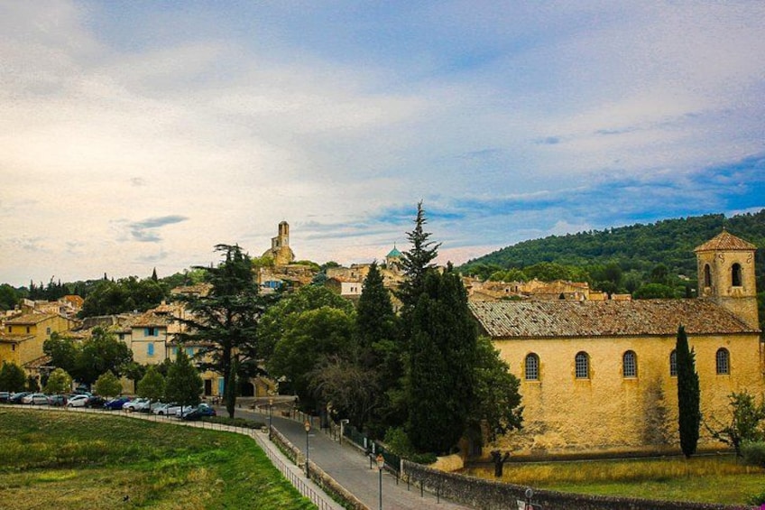 A town with historic buildings, a church, and a hill in the background. 2
